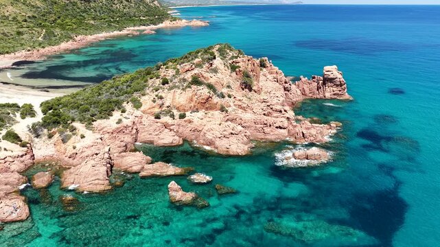 Aerial view of Su Sirboni Beach, Marina di Gairo, Sardinia, Italy. Turquoise sea, rugged red cliffs and hidden coves along the wild Ogliastra coastline