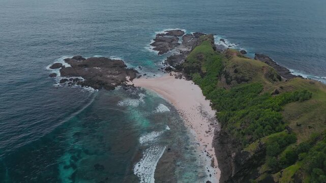 Aerial view bukit merese ridge with turquoise ocean and pink sand beach, sweeping green slopes, rocky cliffs, crystal waves breaking on shore, remote island coastline, dramatic horizon