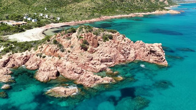 Aerial view of Su Sirboni Beach, Marina di Gairo, Sardinia, Italy. Turquoise sea, rugged red cliffs and hidden coves along the wild Ogliastra coastline