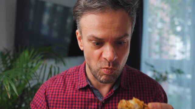 Junk food advertisement concept. Man eating fried chicken, enjoying fast food.