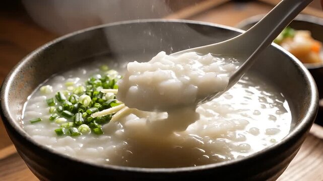 Steaming Bowl of Congee with Scallions and Ginger.