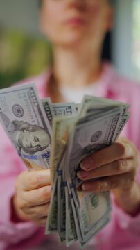 Woman counting US Dollar bills, close-up. Concept of investment and success