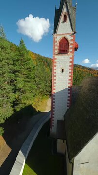 Church of St. Jacob and mountains on the background filmed with FPV drone. Italy