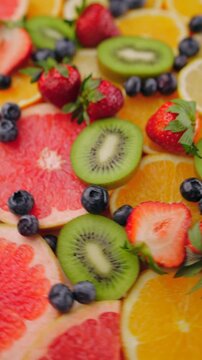 Background of fresh fruits and berries rotating. Vegan sweet food, flat lay.
