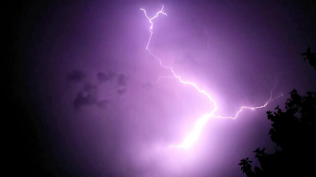 Lightning storm in the night sky flashing with a powerful electric bolt against the dark slow motion 240fps footage