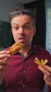 Junk food advertisement concept. Man eating fried chicken, enjoying fast food.
