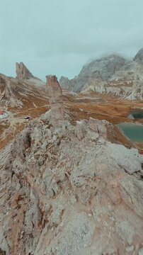FPV drone flying along the surface of mountain cliffs of Cristallo mountain.