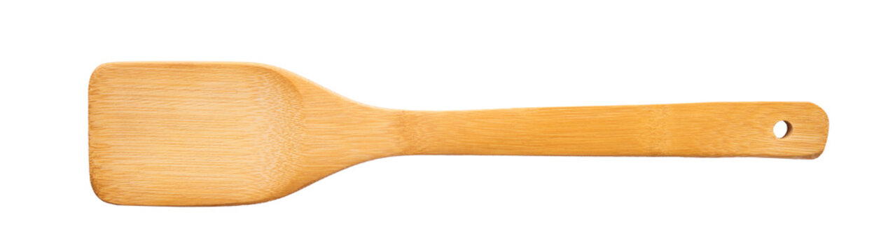 Levitating wooden cooking spatula turner isolated on a pastel white background. Minimalist zero gravity studio kitchen equipment concept.
