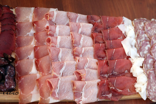 Time for a feast -a board of thinly sliced ​​cured typical Italian meat.