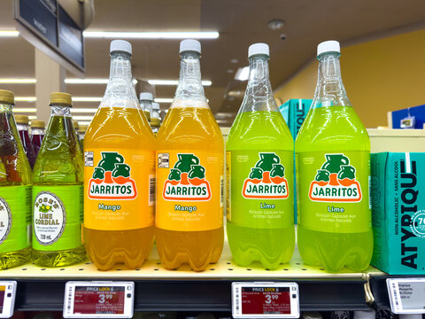Calgary, Alberta, Canada. April 26, 2026. Jarritos mango and lime soda bottles on a retail store shelf with French "natural flavor" labels.