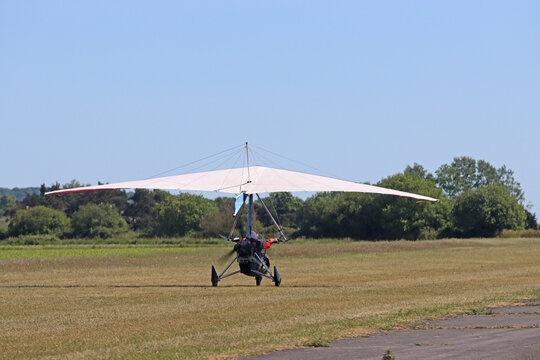 Ultralight airplane taxiing on a grass runway	
