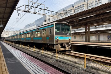 Fototapeta premium Kyoto, Japan - April 10, 2026: Train entering the platform at Kyoto Station, Japan Railways, modern metro and rail infrastructure with dynamic urban travel atmosphere.