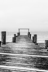 Fototapeta premium A black and white photograph of a wooden pier on Player's Beach on the Isle of Wight
