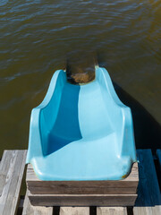 Fototapeta premium A plastic slide mounted on a pier over the lake leading straight into the water.