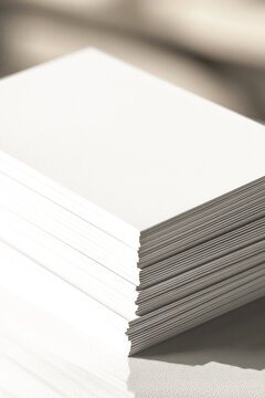 A stack of white cards sitting on a table, possibly used for writing or note-taking vertical frame