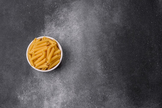 Italian uncooked dry penne regate pasta ready for cooking. Dry penne pasta