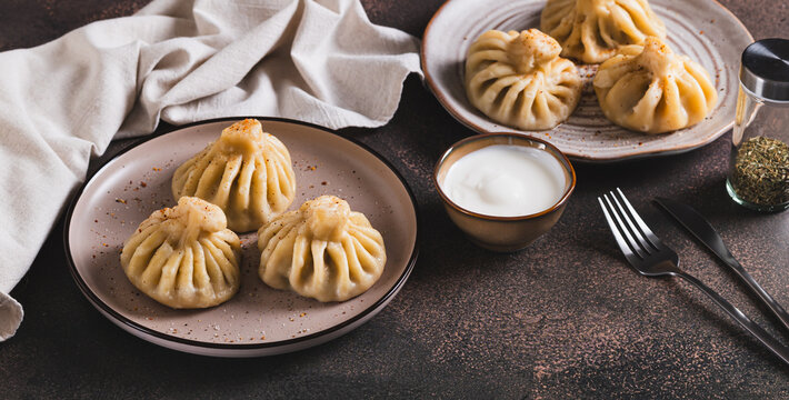 A portion of boiled Georgian khinkali on a plate on the table web banner