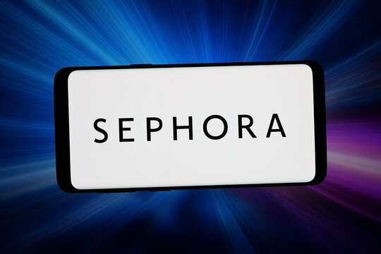 Stuttgart, Germany - 04-16-2026: In this photo illustration, the logo of French cosmetics retail company Sephora S.A. is displayed on a smartphone in front of abstract background on computer screen.