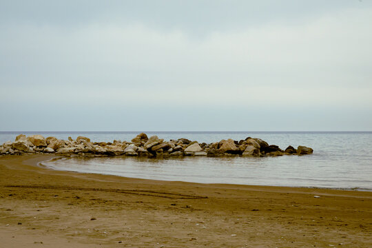 Tranquil Zapalo Beach with rock breakwater and sandy shore in Limassol, Cyprus