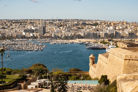 Horizontal view of Grand Harbour and Sliema cityscape from Valletta. Historic fort bastions and luxury yacht marina in Malta.
