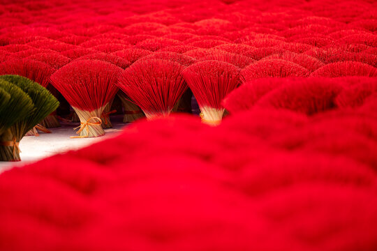 Traditional incense stick production in vietnamese village with vibrant red sticks