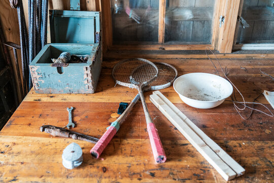 Svalbard, Svalbard and Jan Mayen - 21 June 2025: View of vintage tennis rackets, a white bowl, and old tools on a wooden workbench inside the historic Kinnvika Station.