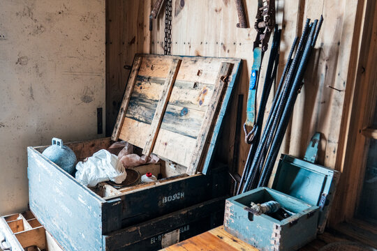Svalbard, Svalbard and Jan Mayen - 21 June 2025: View of the interior of Kinnvika Station featuring wooden storage crates and equipment inside a rustic cabin.