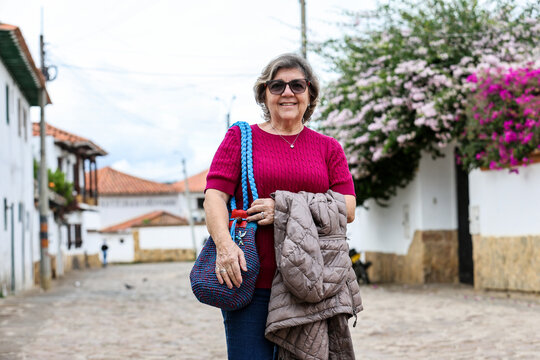 Happy senior woman concept. Senior travel concept. Senior woman at the beautiful colonial town of Villa de Leyva in Colombia