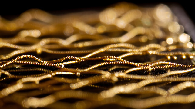 Abstract close-up of intricate golden threads or wires, reflecting light with blurred background elements, creating a luxurious and textured visual