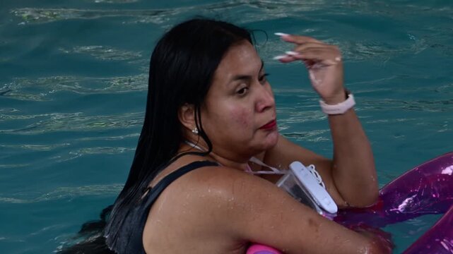 Woman in a pool with a lifeguard.