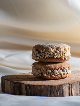 Alfajores cookies stacked on wooden board with rustic background