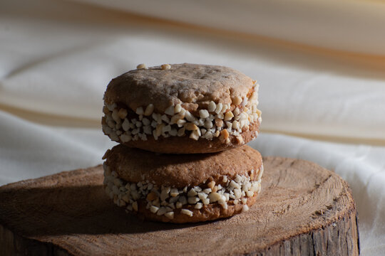 Sweet sandwich cookies with caramel filling on rustic table