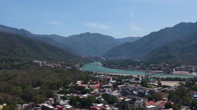 Drone view of rishikesh city showing houses, bridges and holy ganga river 