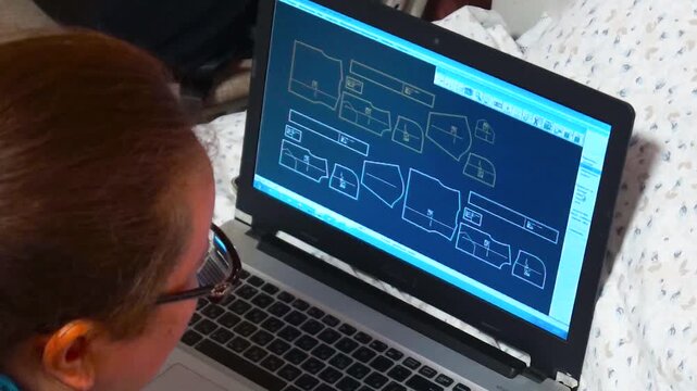 A tailor drafts complex sewing patterns on her laptop while resting. The scene captures the intersection of traditional needlecraft and advanced digital design technology.