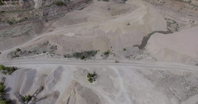 Industrial Quarry Overview. High Angle Drone Capture of Quarry and Industrial Terrain. Elevated Perspective of Mining Operations with Raw Material Storage and Access Roads