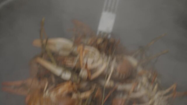 Boiling shellfish with steam rising high. Fresh crabs and shellfish prepared in steaming cooking process. Closeup shot of steaming crustaceans in busy kitchen setting