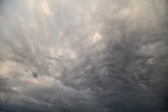 Stormy sky ahead. Dark clouds gather intensively. Foreboding clouds threaten imminent weather shift. Gloomy skies with rolling cloud formations signal upcoming stormy weather