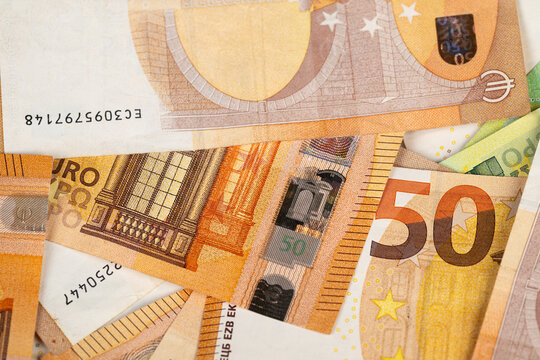 Inspecting currency for authenticity details. Detailed examination of euro banknotes emphasizing security elements like holographic features and microprint patterns