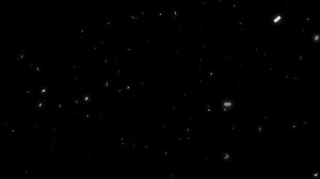 Atmospheric light particles slowly falling like snow or confetti against a dark background in slow motion video