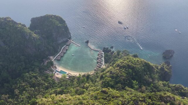 Lagen Island, a dramatic limestone island, rises in Bacuit Bay, El Nido. This area in the Philippines is a popular vacation destination due to its beautiful coral reefs, beaches, and hidden lagoons.