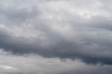Fototapeta premium Stormy sky scenario. Overcast atmosphere with billowing shelf formations and dark shading. Brooding weather scene featuring sweeping layered clouds and intense shadowing