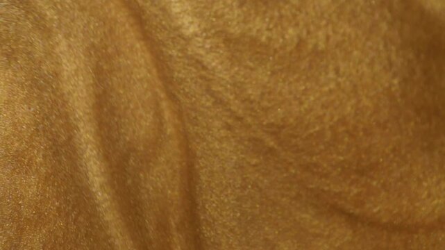 gold sparkling swirl texture backdrop.molten gold texture with flowing swirls and radiant glitter reflections.
