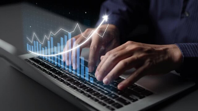 A close-up view of hands typing on a laptop, overlaid with a financial graph representing growth and data analysis, ideal for business and technology themes. Copula