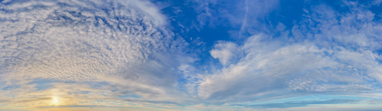 Panoramic Cloudscape at Sunrise With Blue Sky and Textured Wispy Clouds Over Horizon
