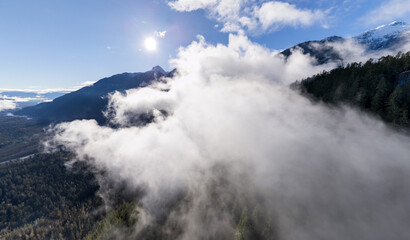 Sunlit Fog Rolling Over Forested Mountains and Snow-Capped Peaks in British Columbia, Canada © edb3_16