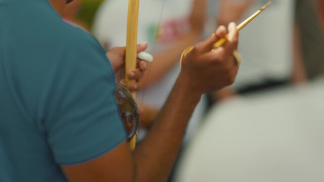 Musician playing berimbau musical instrument during capoeira