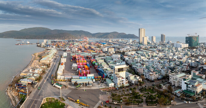 Aerial view of the bustling port and city of Quy Nhon, Binh Dinh, Vietnam, showcasing cargo ships, container yards, and urban development along the coast.