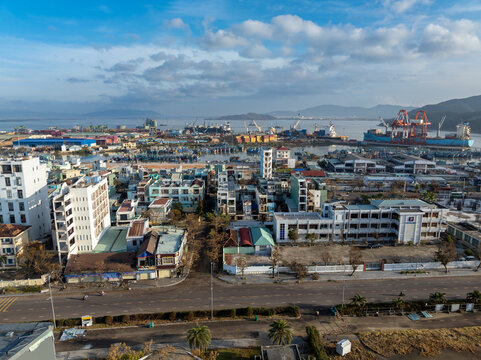 A panoramic view of the coastal city iof Quy Nhon, Binh Dinh, Vietnam with a busy port and residential areas. The image captures the daily life and industrial activity of the city.