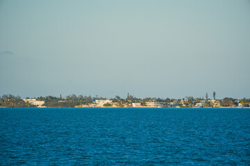 Fototapeta premium Coastal residential houses and green trees along the blue Atlantic Ocean water in the Florida Keys islands, USA.