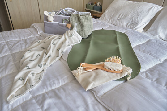 Newborn items with organic cotton textiles and natural wood brushes for health and comfort